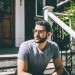 Man modeling Atticus eyeglasses in oak barrel